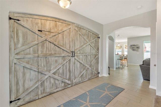 entryway with baseboards and arched walkways