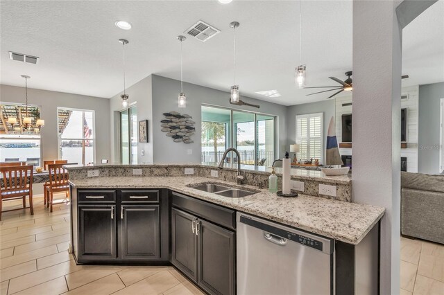 kitchen with visible vents, open floor plan, ceiling fan with notable chandelier, stainless steel dishwasher, and a sink