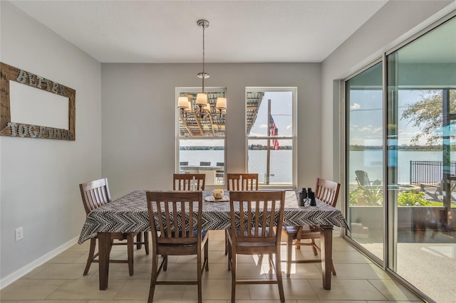 dining room with a healthy amount of sunlight, baseboards, and an inviting chandelier