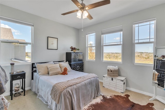 bedroom with a ceiling fan, baseboards, and carpet floors