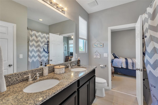 ensuite bathroom featuring double vanity, ensuite bath, and a sink