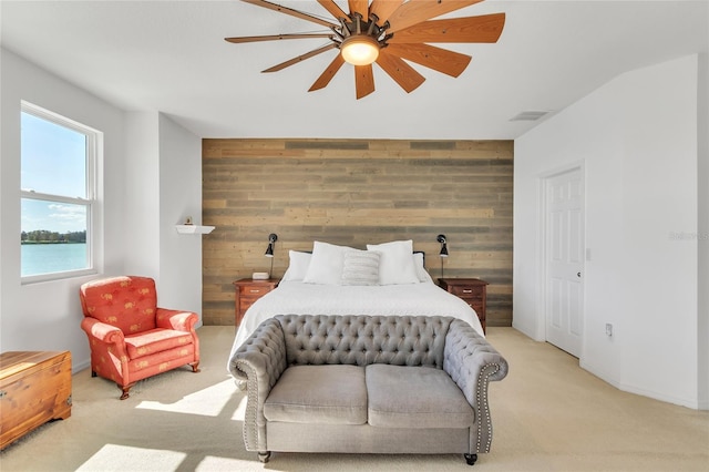 bedroom with visible vents, carpet floors, wood walls, and an accent wall