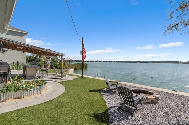 view of yard featuring a patio area, a water view, and an outdoor fire pit