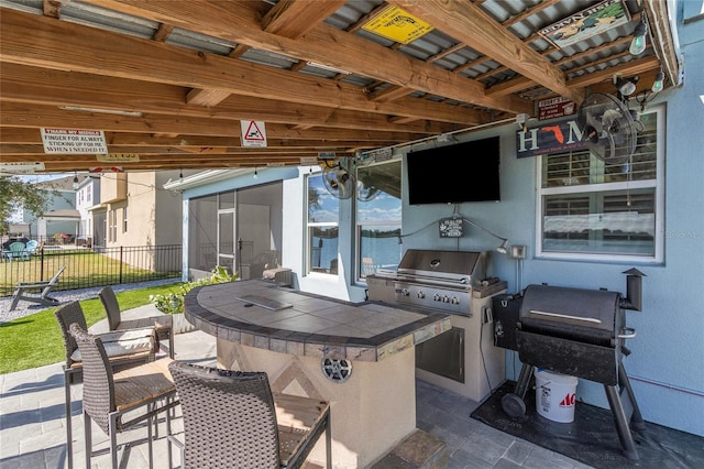 view of patio / terrace featuring a grill, an outdoor kitchen, outdoor dry bar, and fence