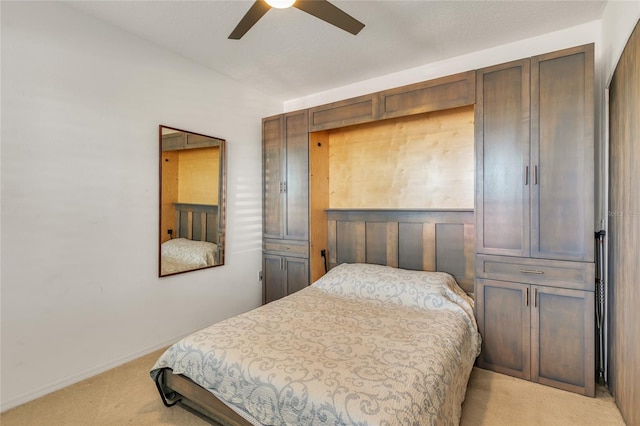 bedroom featuring light carpet, a ceiling fan, and baseboards