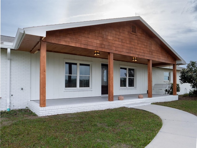 exterior space with covered porch and a front lawn