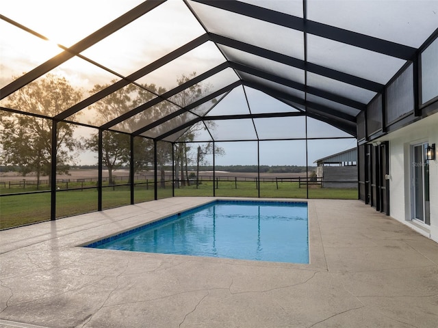 pool at dusk with a lawn, a patio area, and a lanai