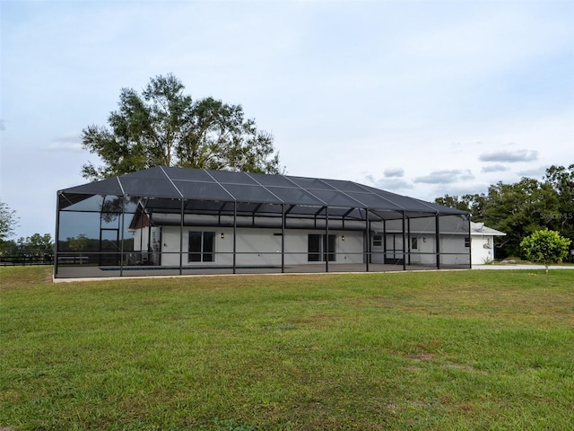 back of property featuring a lanai and a yard