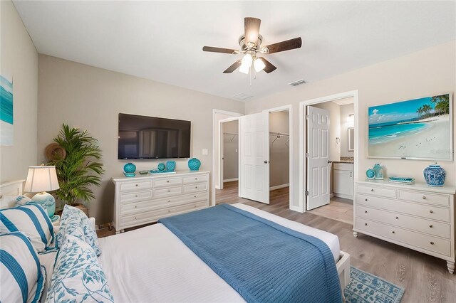 bedroom featuring ensuite bathroom, ceiling fan, a spacious closet, light hardwood / wood-style floors, and a closet