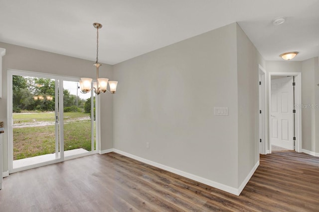 unfurnished dining area with a chandelier and dark wood-type flooring