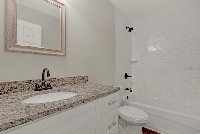 full bathroom with tiled shower / bath, vanity, and toilet