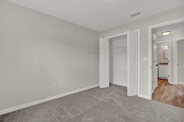 unfurnished bedroom with light carpet and a closet