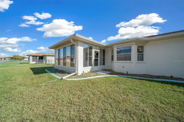 view of home's exterior featuring a sunroom and a yard