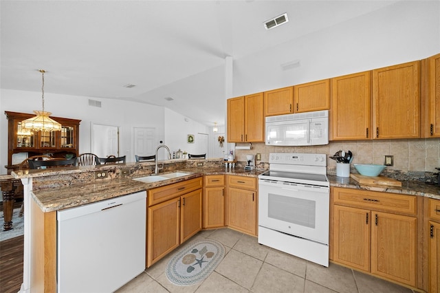 kitchen with lofted ceiling, white appliances, kitchen peninsula, and a chandelier