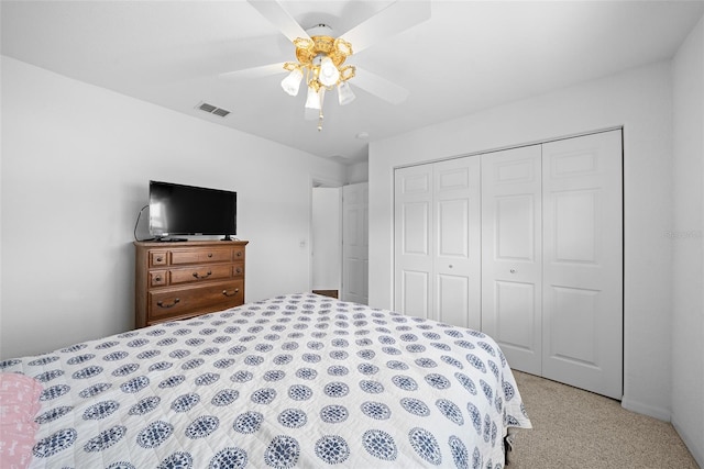 bedroom with ceiling fan, a closet, and light colored carpet