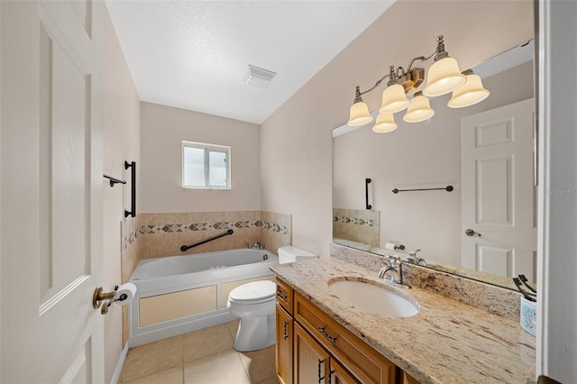 bathroom featuring tile patterned floors, a bathtub, vanity, and toilet