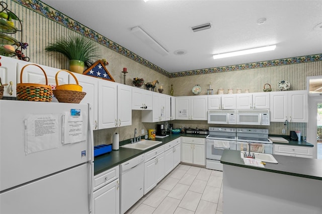 kitchen featuring white appliances, white cabinetry, and sink