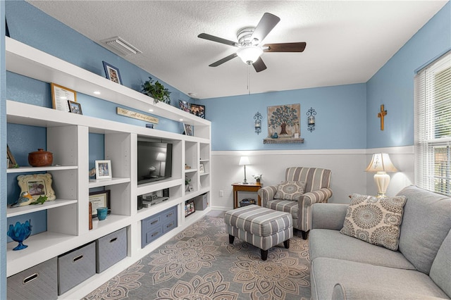 living room featuring a textured ceiling and ceiling fan