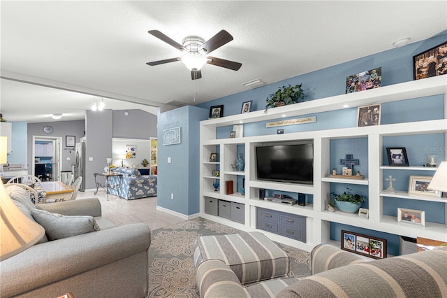 living room with a textured ceiling, ceiling fan, and lofted ceiling