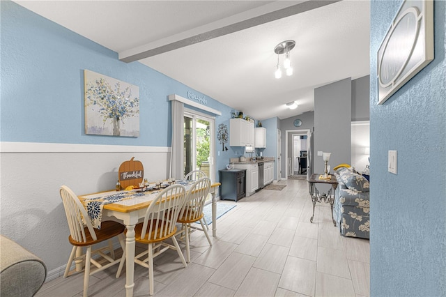 dining space featuring vaulted ceiling with beams