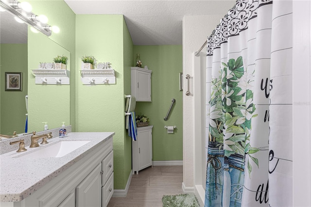 bathroom with hardwood / wood-style floors, vanity, a textured ceiling, and a shower with shower curtain