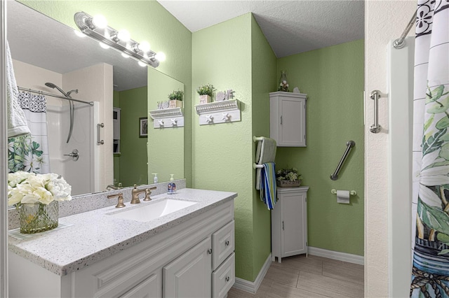 bathroom with hardwood / wood-style floors, vanity, a textured ceiling, and walk in shower