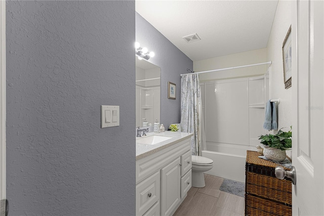 full bathroom featuring shower / bath combo, vanity, a textured ceiling, and toilet