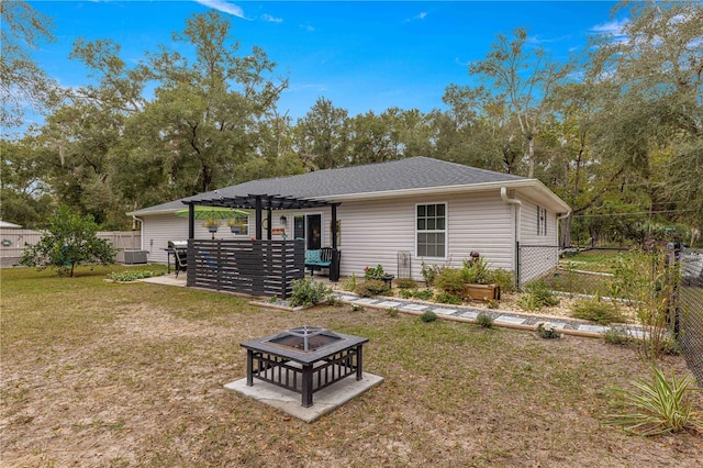 back of property with a pergola, central air condition unit, a lawn, and an outdoor fire pit