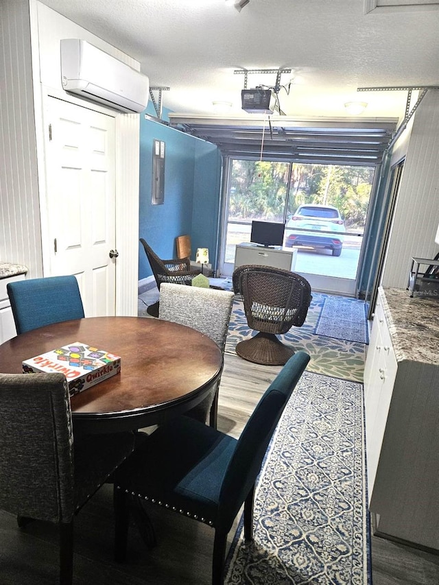 dining space featuring a textured ceiling and a wall mounted AC