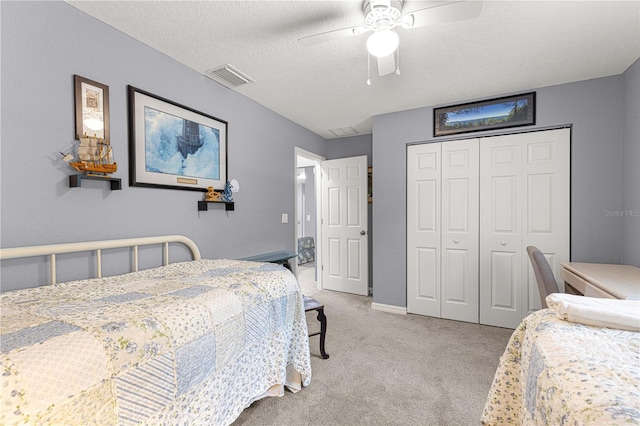 bedroom with visible vents, light colored carpet, ceiling fan, a textured ceiling, and a closet