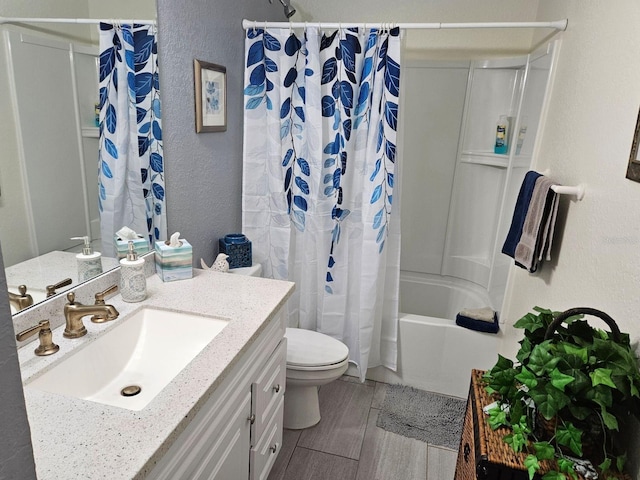 full bathroom featuring a textured wall, toilet, shower / bath combo with shower curtain, wood tiled floor, and vanity