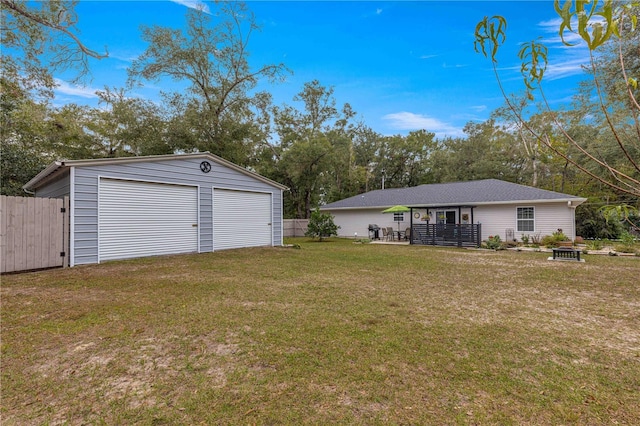 view of yard with an outbuilding, a detached garage, and fence