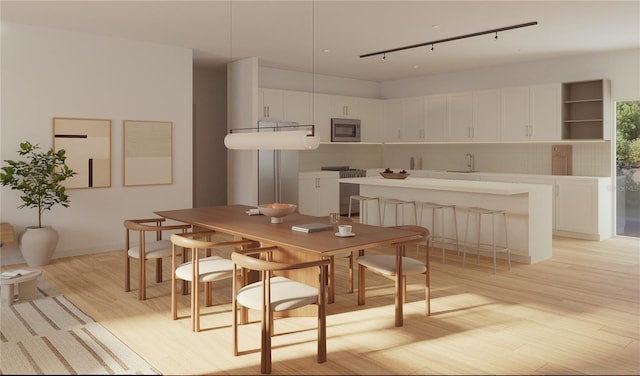 dining space with light hardwood / wood-style flooring and sink