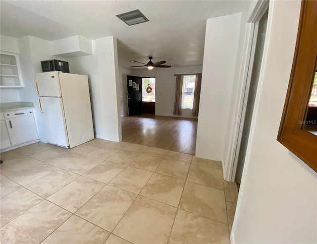 kitchen with white refrigerator, white cabinetry, light hardwood / wood-style flooring, and ceiling fan