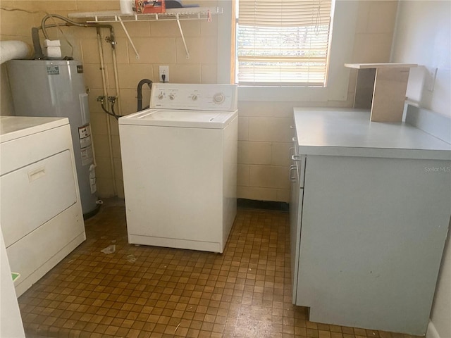 laundry room featuring washer / dryer, electric water heater, and tile walls