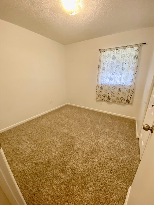 carpeted empty room with a textured ceiling