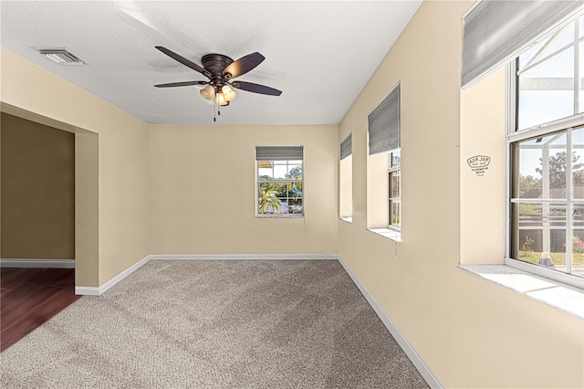 unfurnished room featuring carpet, ceiling fan, and a textured ceiling