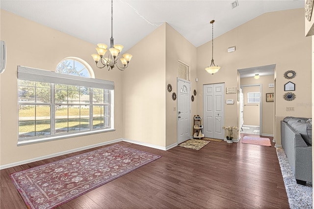 foyer entrance featuring dark hardwood / wood-style flooring, high vaulted ceiling, and a chandelier