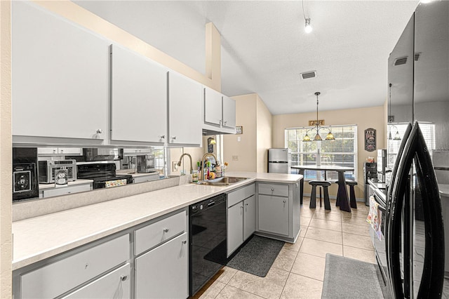 kitchen featuring a textured ceiling, sink, black appliances, pendant lighting, and light tile patterned flooring