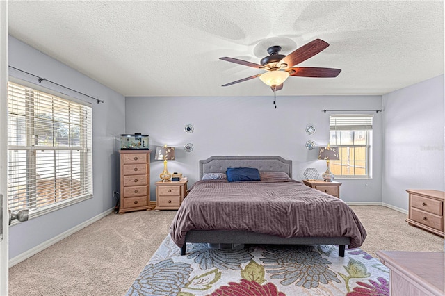 carpeted bedroom featuring a textured ceiling and ceiling fan