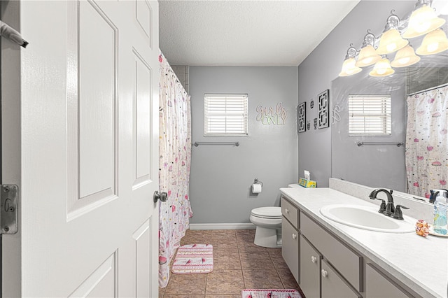 bathroom with tile patterned flooring, a textured ceiling, vanity, and toilet