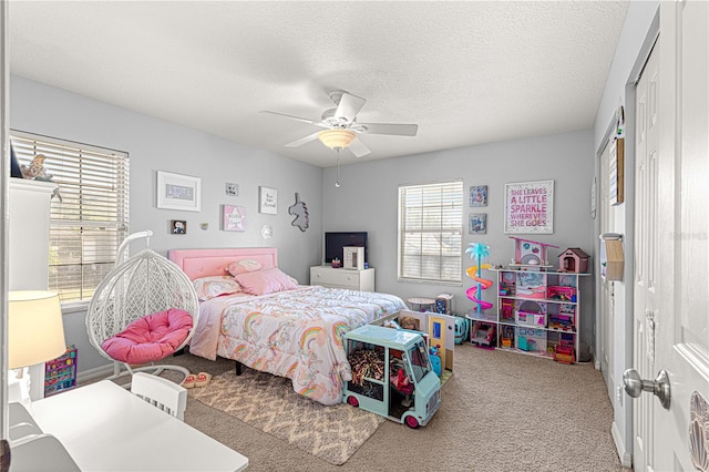 carpeted bedroom featuring ceiling fan and a textured ceiling