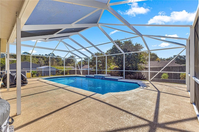 view of pool with glass enclosure and a patio area