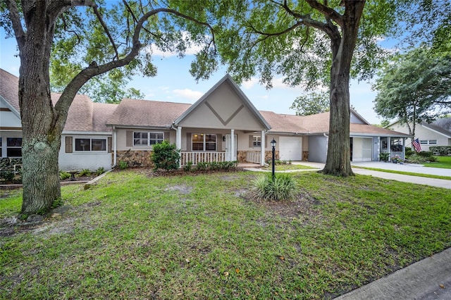 view of front of house with covered porch, a garage, and a front lawn