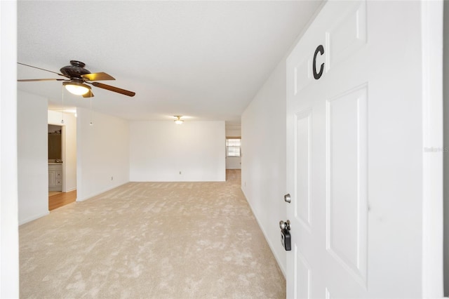 unfurnished room with ceiling fan and light colored carpet