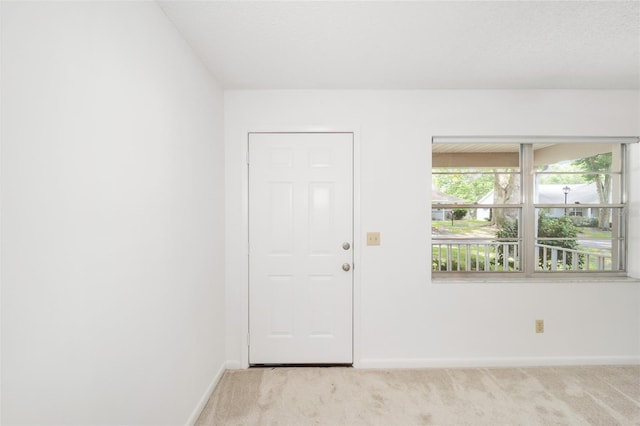 carpeted foyer entrance featuring a textured ceiling