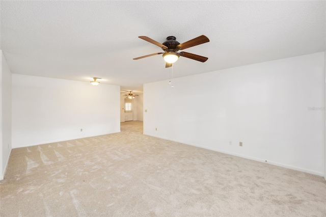 carpeted empty room featuring ceiling fan and a textured ceiling