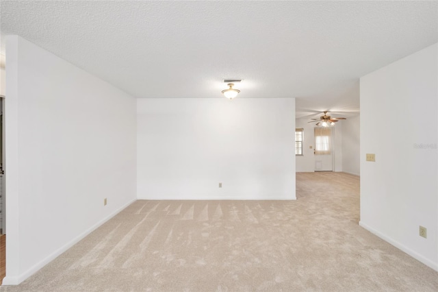 empty room with a textured ceiling and light carpet