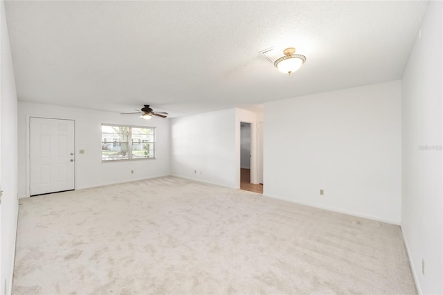 empty room with ceiling fan and light carpet