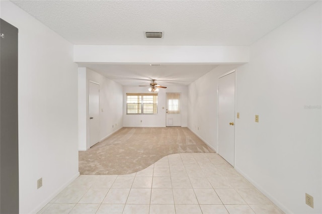 tiled empty room featuring ceiling fan and a textured ceiling